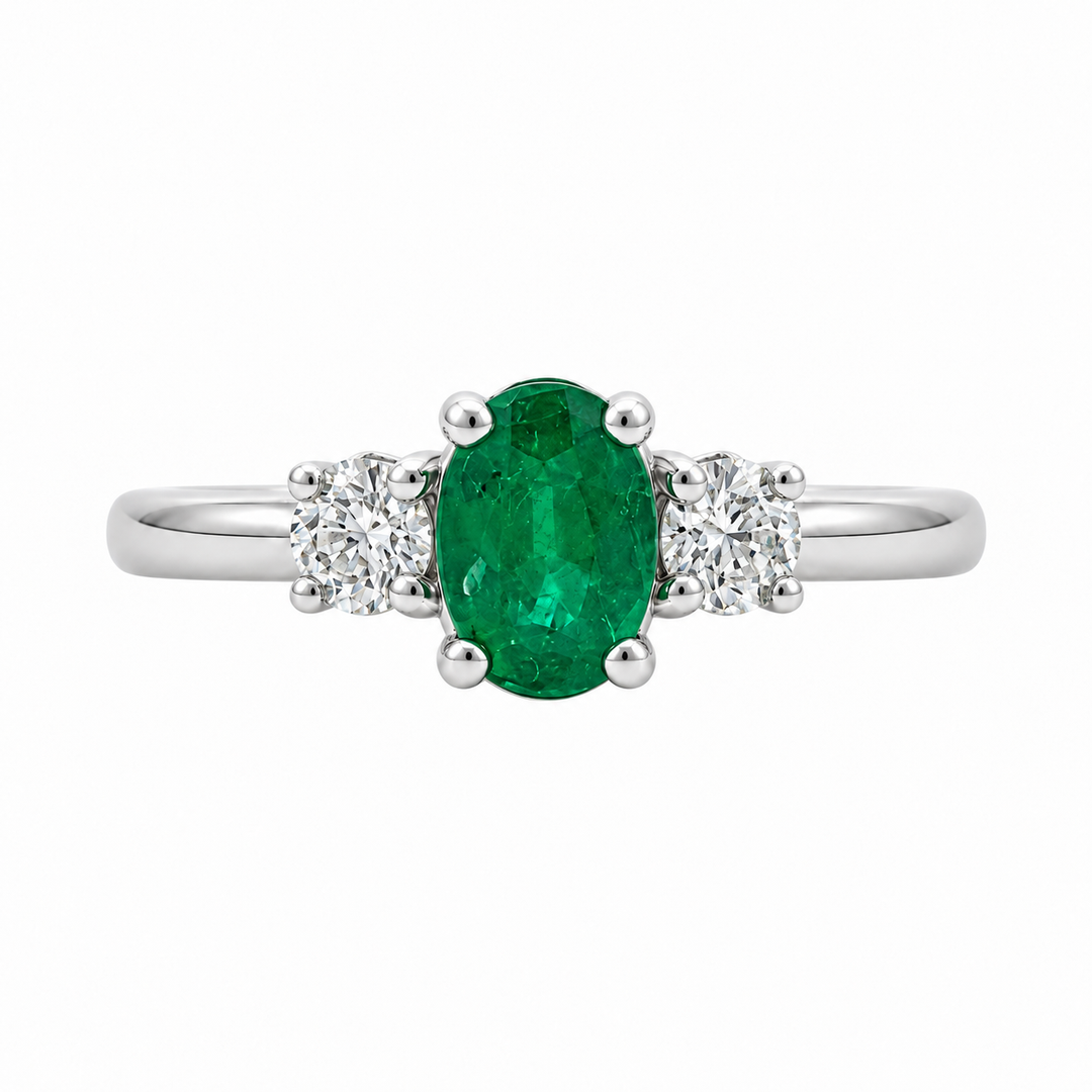 14K white gold emerald and diamond three stone ring featuring a 0.79CT emerald accented by sparkling diamonds.