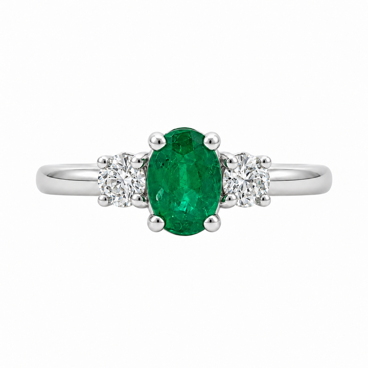 14K white gold emerald and diamond three stone ring featuring a 0.79CT emerald accented by sparkling diamonds.