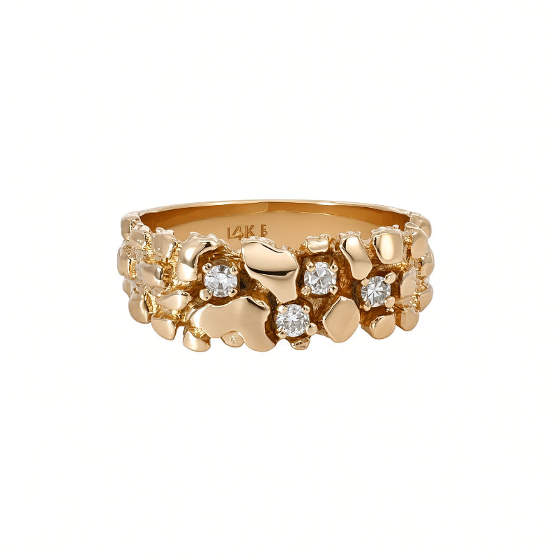 A gold ring with a textured, organic chunky design accented by small clear gemstones