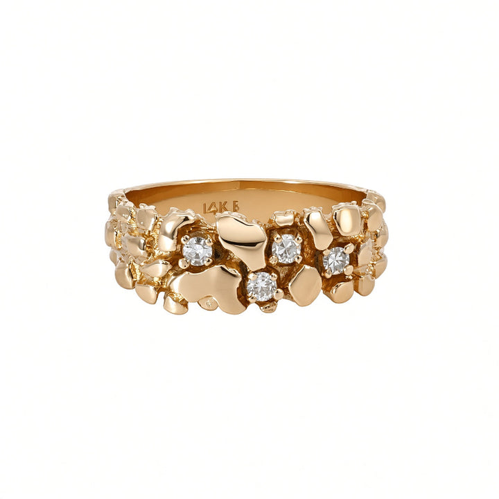 A gold ring with a textured, organic chunky design accented by small clear gemstones