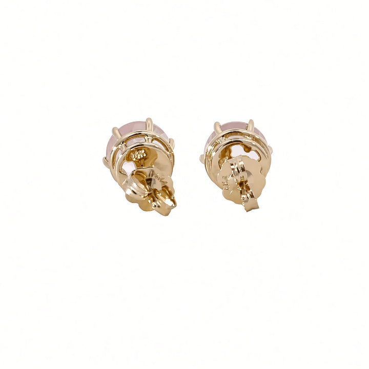 A pair of gold stud earrings with a small round pale pink stone