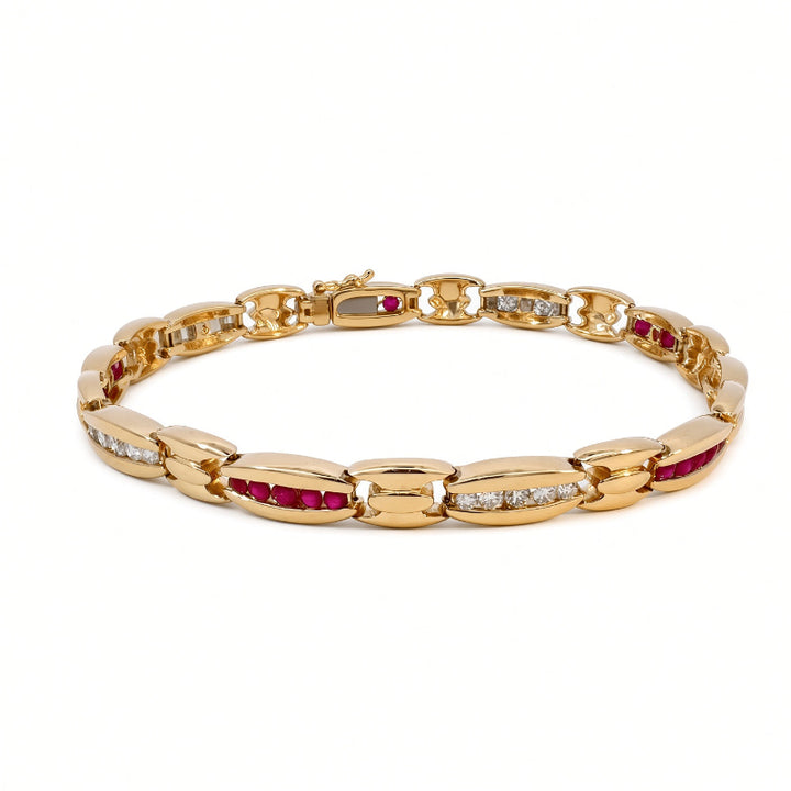 A yellow gold tennis bracelet featuring oval links set with vibrant red rubies and rows of small clear stones