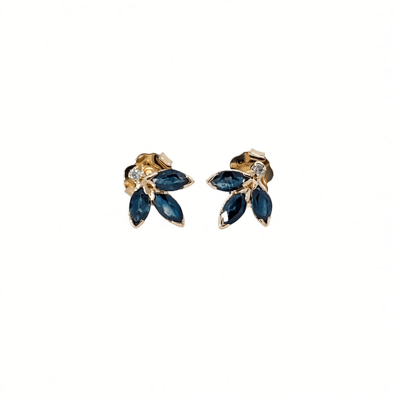 A pair of gold-toned stud earrings featuring marquise-cut dark blue gemstones and a small clear accent stone