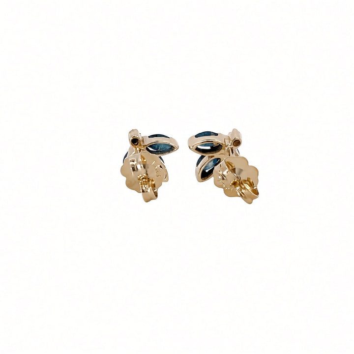 A pair of gold-toned floral stud earrings with small dark blue marquise-cut stones.